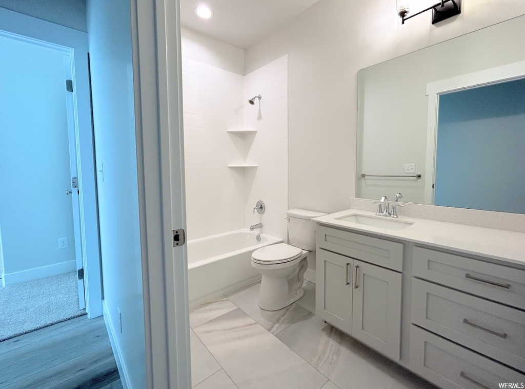 Full bathroom featuring tile floors, large vanity, toilet, and  shower combination