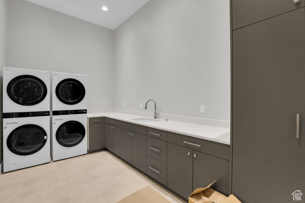 Washroom with cabinets, sink, washing machine and dryer, and stacked washer / dryer
