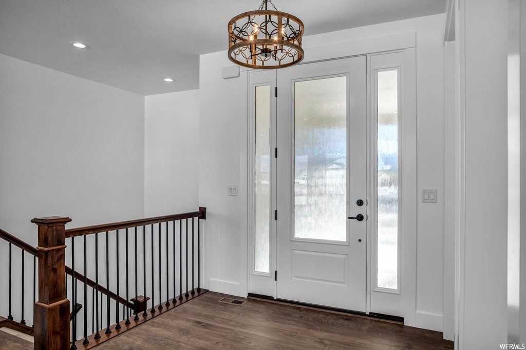 Foyer entrance featuring dark hardwood / wood-style flooring and an inviting chandelier