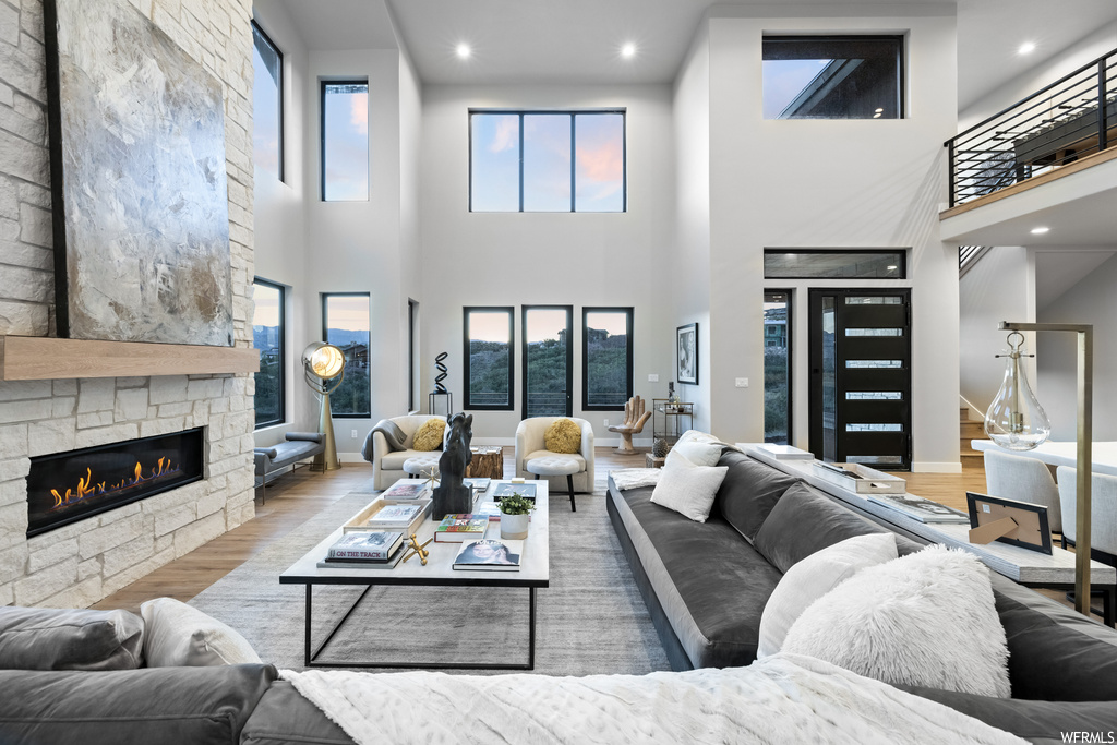 Hardwood floored living room with a fireplace and a high ceiling