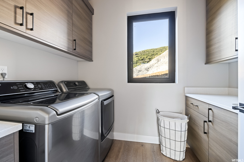 Washroom featuring dark hardwood floors and washer and dryer