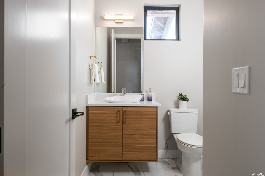 Bathroom featuring oversized vanity, mirror, and light tile flooring