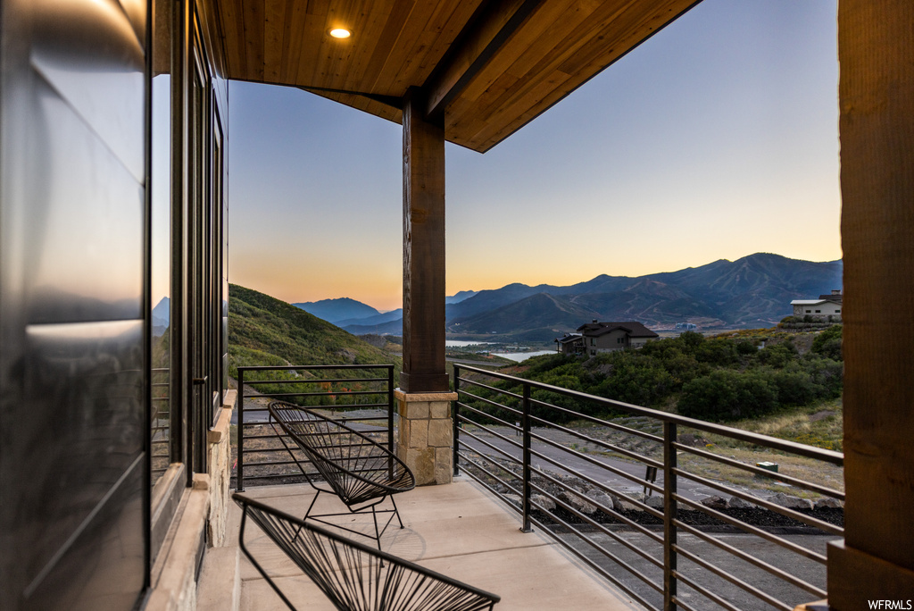 Balcony at dusk featuring a mountain view