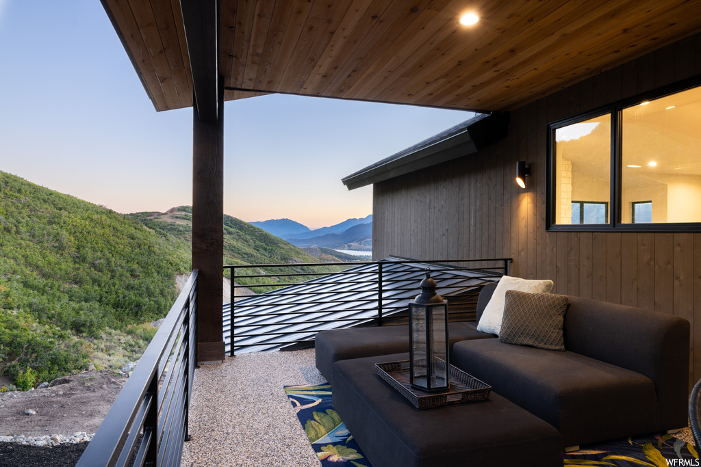 Balcony at dusk featuring a mountain view