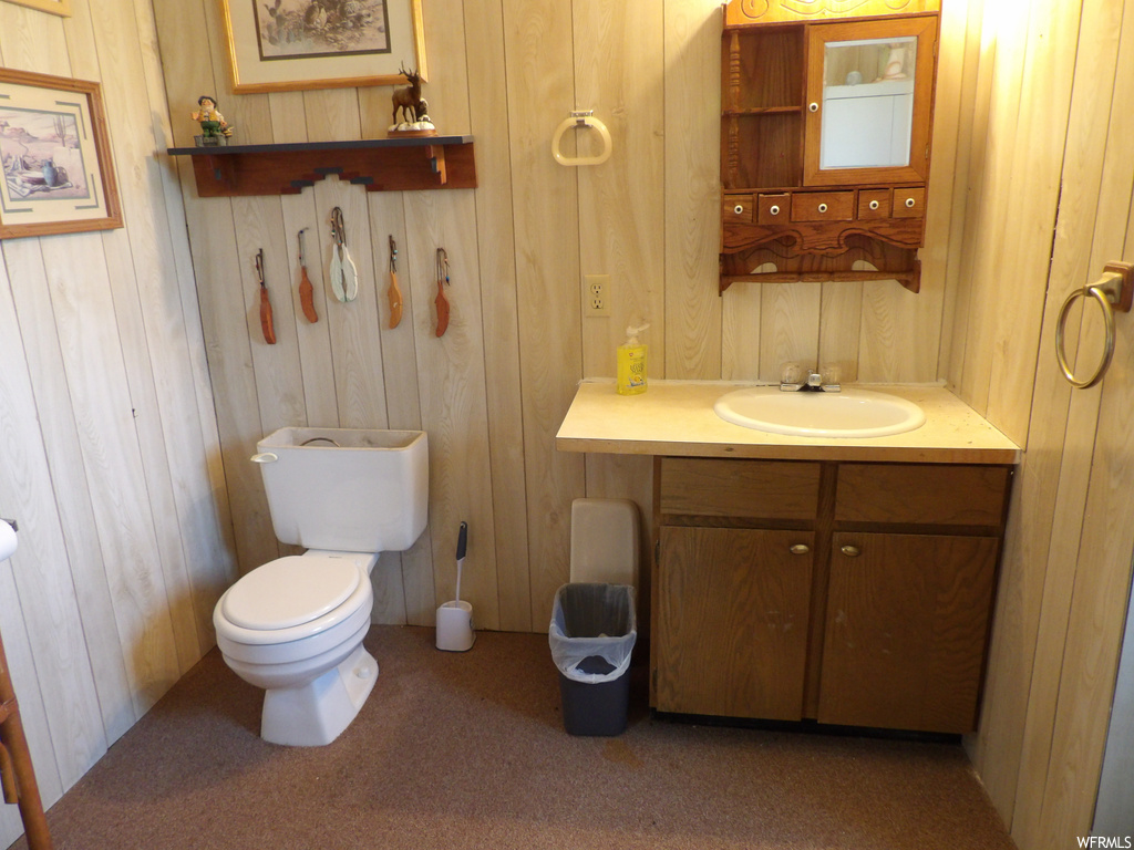 Half bathroom with toilet, mirror, and vanity