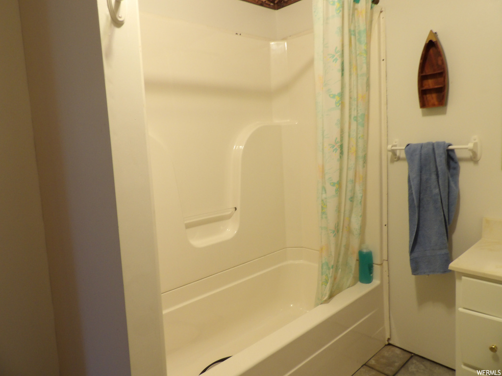 Bathroom featuring tile flooring, shower curtain, and shower / bathing tub combination