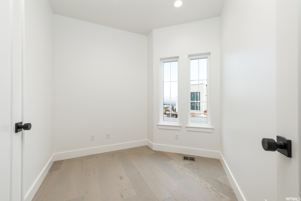 spare room with natural light and hardwood floors