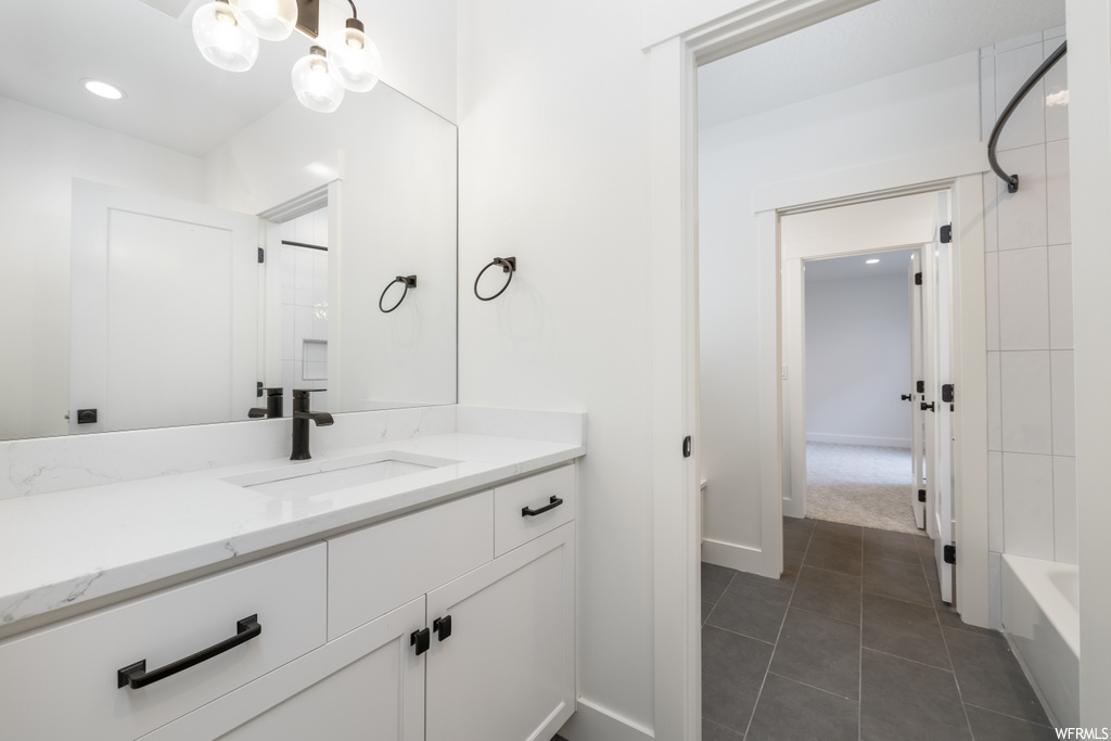 bathroom with tile flooring, vanity, mirror, and shower / washtub combination