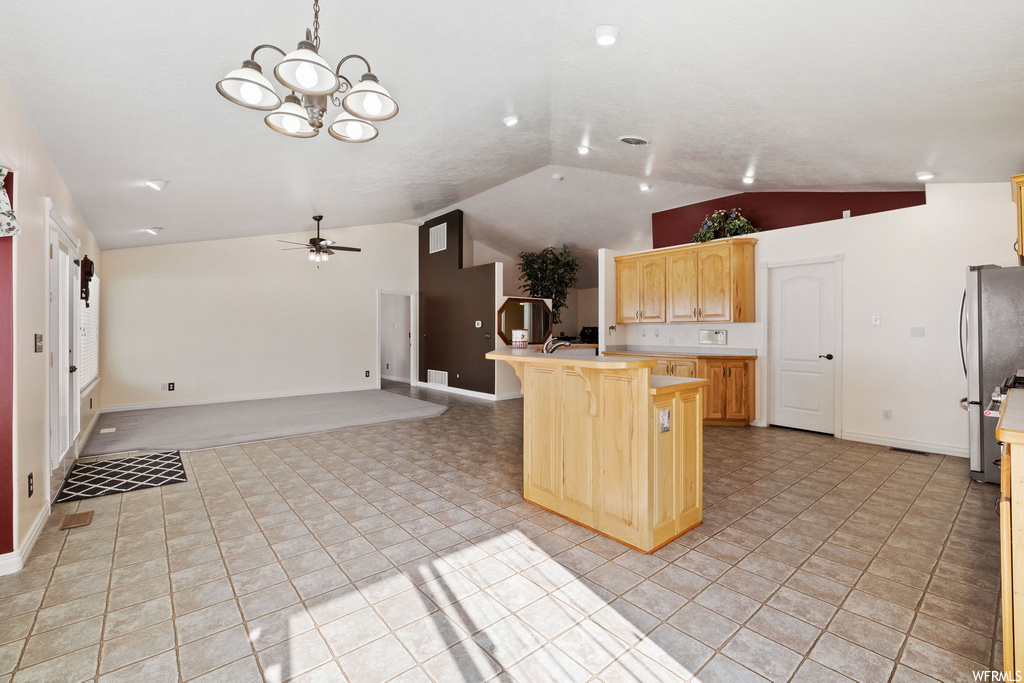kitchen with a ceiling fan, vaulted ceiling, light countertops, and light tile floors