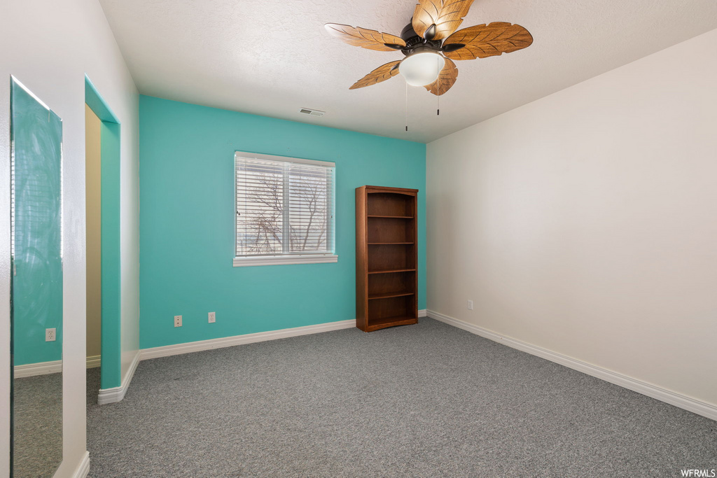 carpeted bedroom with natural light and a ceiling fan