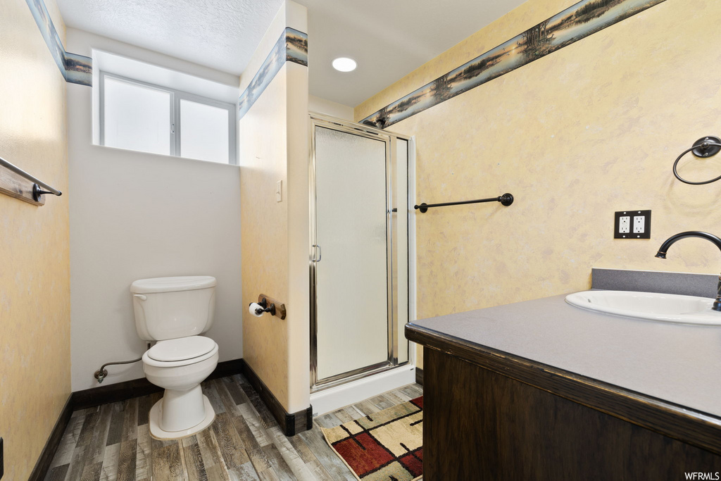 full bathroom with hardwood floors, vanity, toilet, and shower cabin