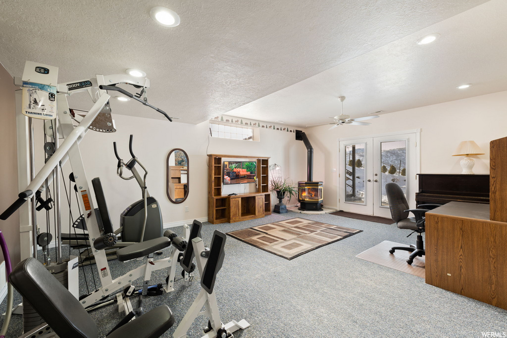 exercise room with carpet, a ceiling fan, and french doors