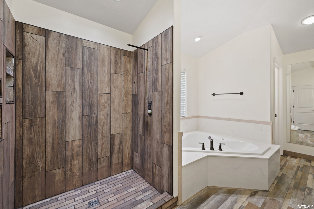 bathroom featuring hardwood flooring and separate shower and tub