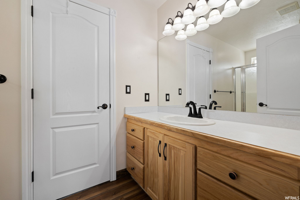 bathroom with wood-type flooring, mirror, and vanity