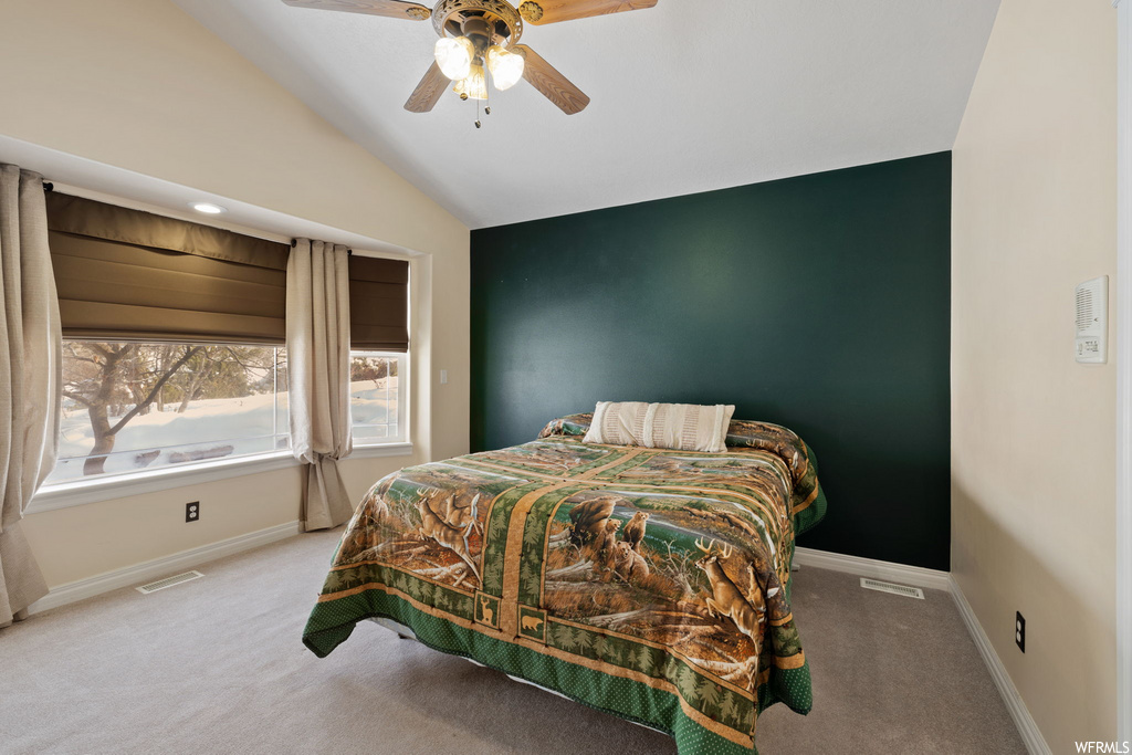 bedroom with lofted ceiling, carpet, natural light, and a ceiling fan