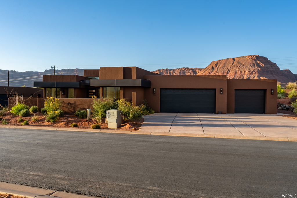 View of front of property with garage and a mountain view