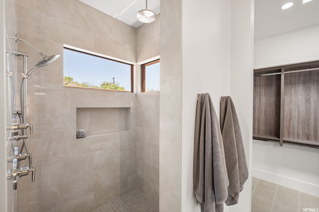 Bathroom featuring a tile shower and light tile floors