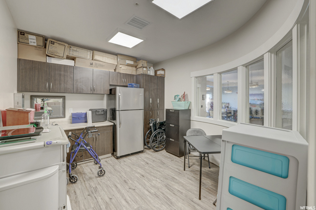 kitchen featuring refrigerator, light hardwood floors, and light countertops