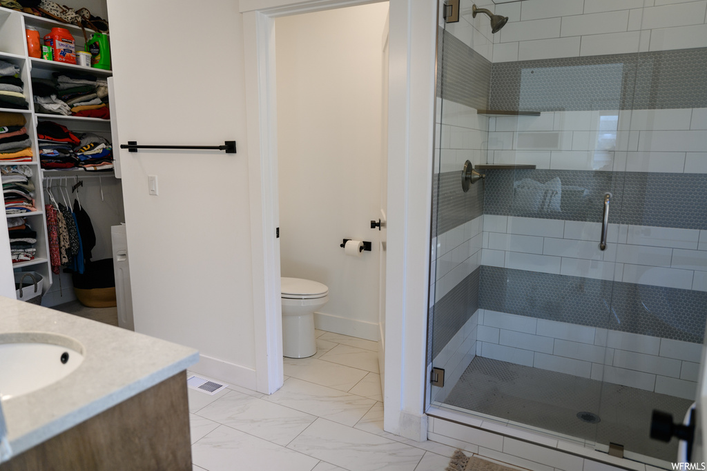 full bathroom with tile flooring, toilet, vanity, and enclosed shower