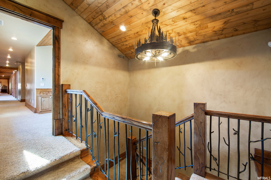 stairway with carpet and a chandelier