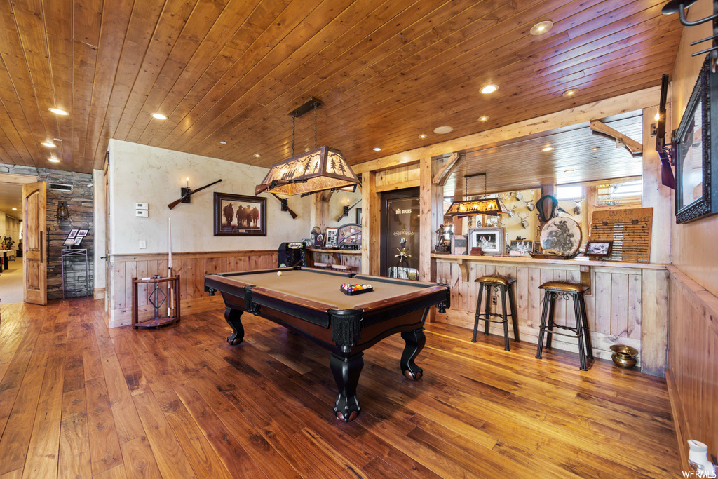 game room featuring a kitchen bar and hardwood flooring