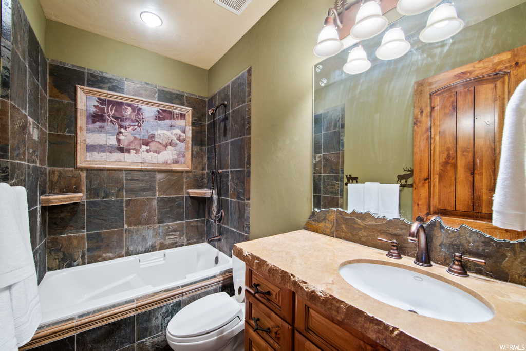 full bathroom featuring shower / bathing tub combination, toilet, vanity with extensive cabinet space, and mirror