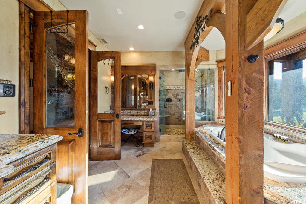 bathroom with tile flooring, natural light, vanity, and shower with shower door