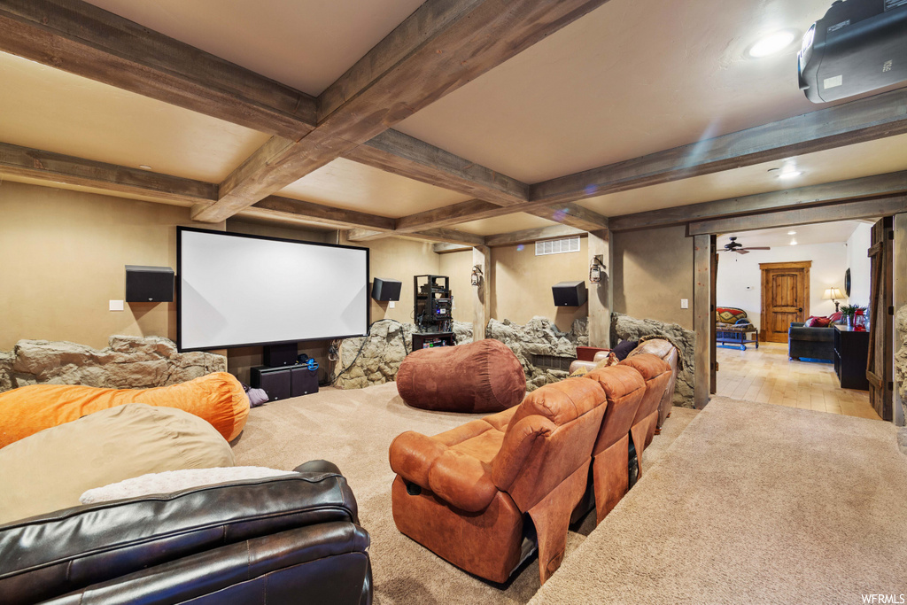 cinema room with beamed ceiling and hardwood floors