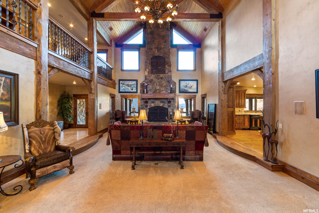 office space with a high ceiling, natural light, vaulted ceiling with beams, a fireplace, and carpet