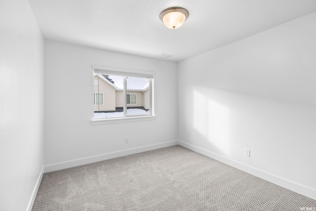carpeted spare room featuring natural light