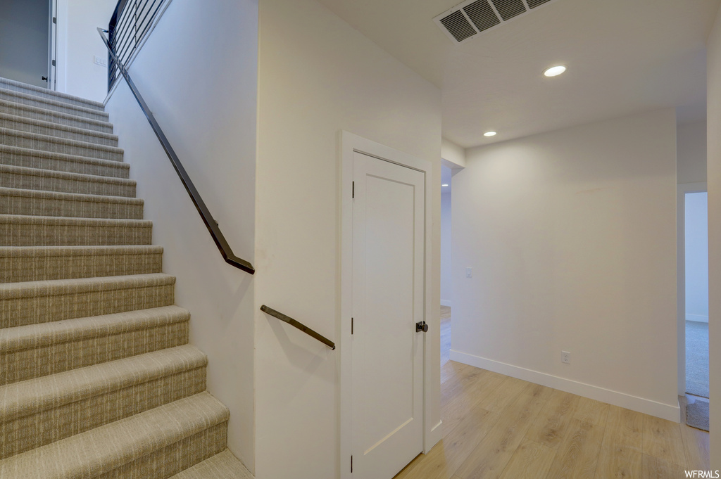 Staircase featuring hardwood floors
