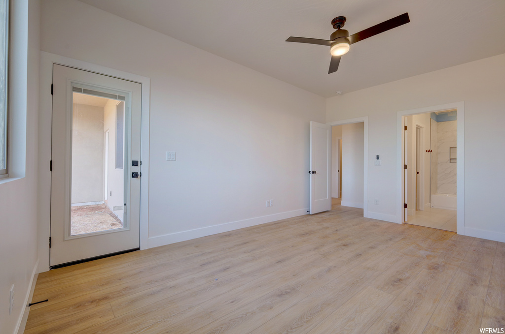 Hardwood floored bedroom with a ceiling fan