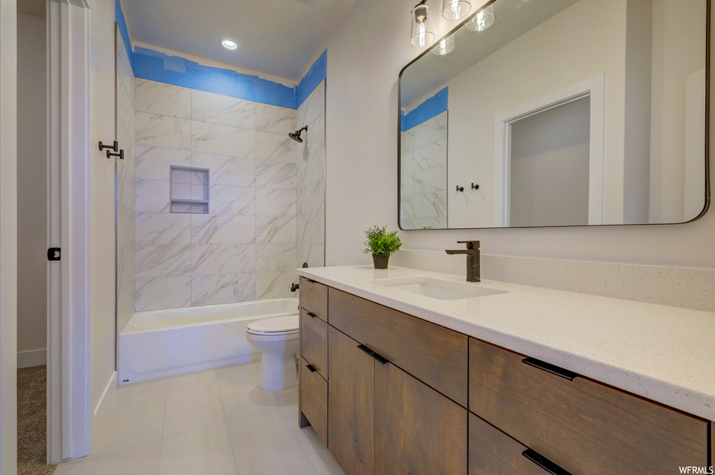 Full bathroom with tile flooring, toilet, mirror, shower / washtub combination, and vanity