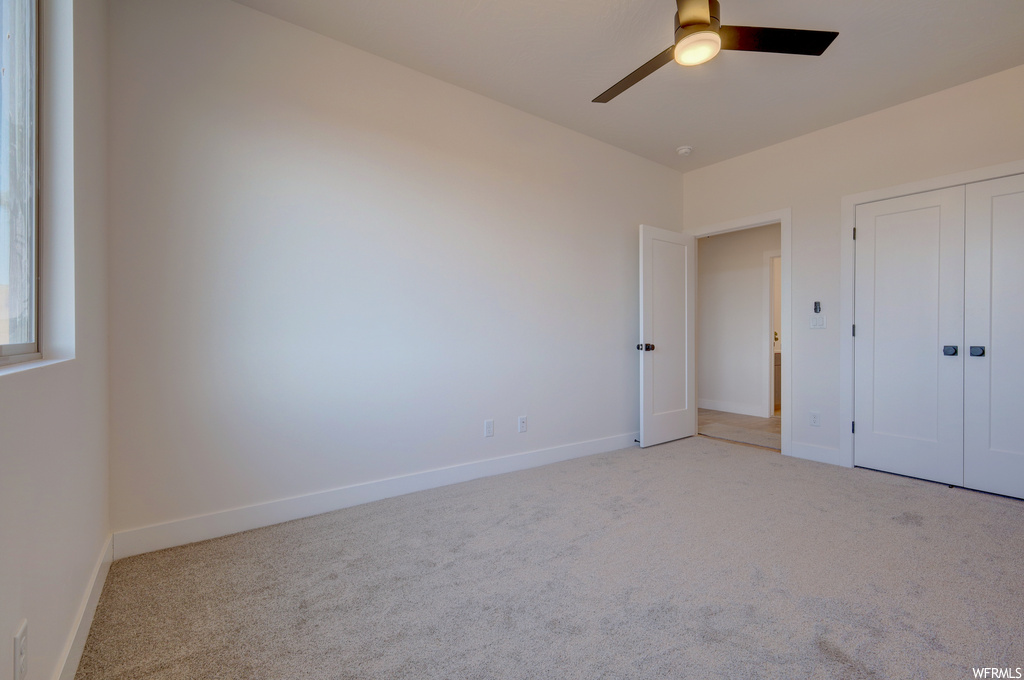 Bedroom featuring a ceiling fan and carpet