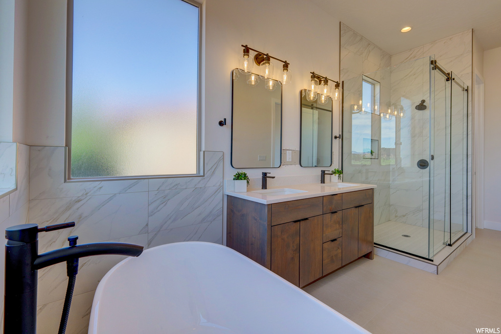 Bathroom with dual bowl vanity, mirror, and shower with separate bathtub