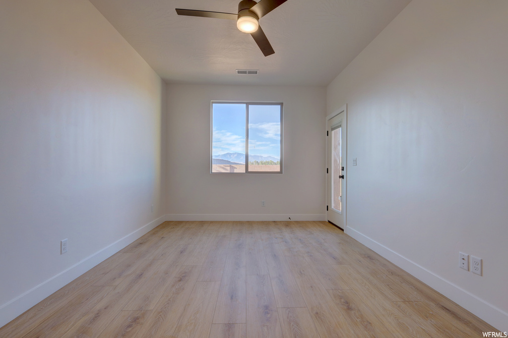 Hardwood floored spare room featuring natural light