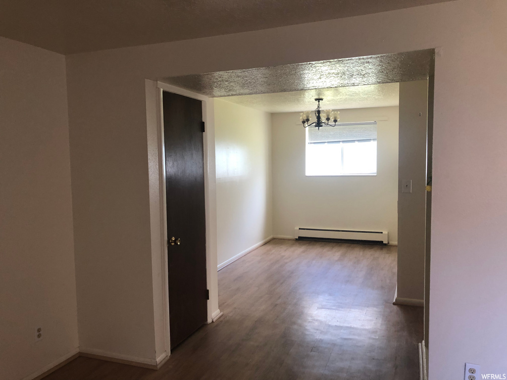 interior space with hardwood flooring, natural light, and baseboard radiator
