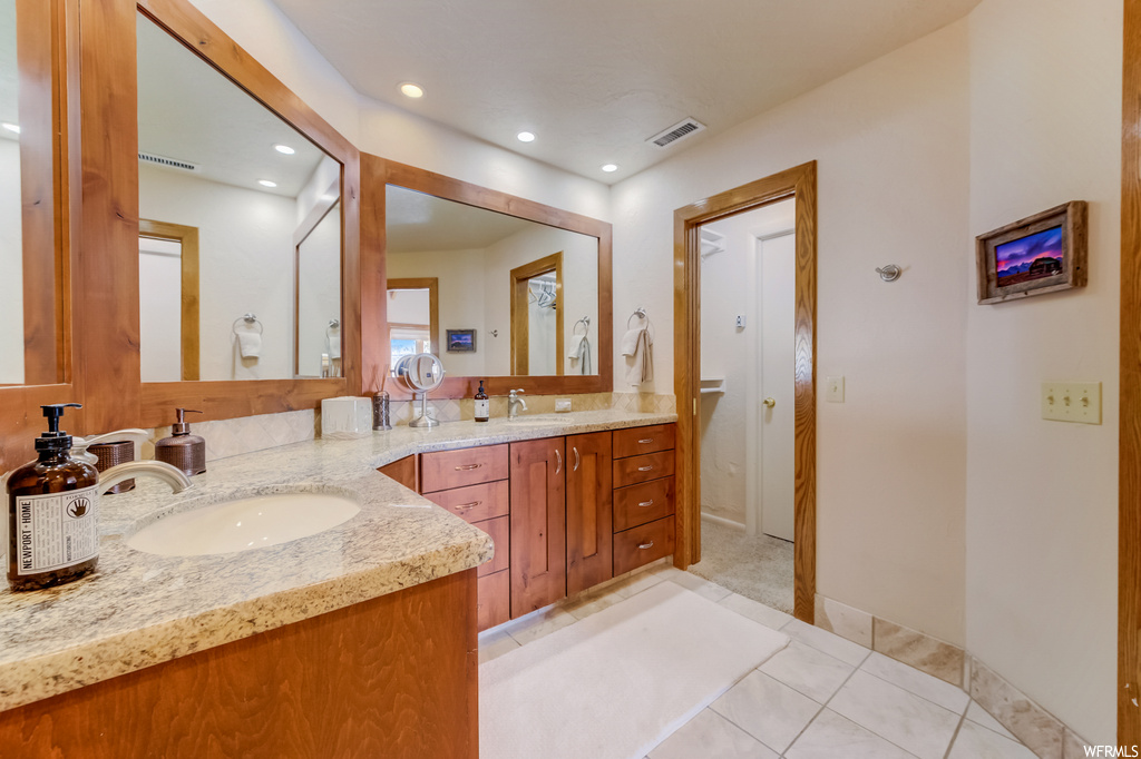 bathroom featuring tile flooring, dual large bowl vanity, and dual mirrors