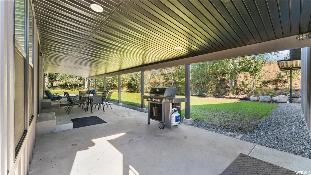 View of patio with a grill