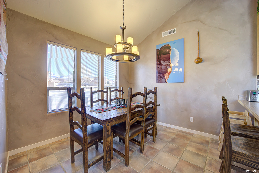 tiled dining room featuring a notable chandelier and natural light