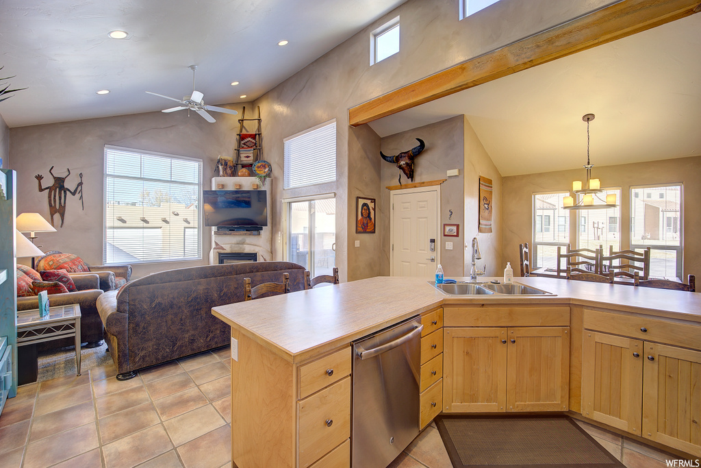kitchen featuring natural light, a ceiling fan, skylight, stainless steel dishwasher, TV, light tile floors, and light countertops