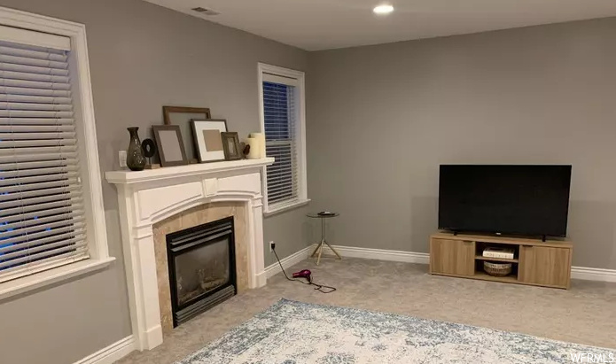 carpeted living room featuring a fireplace and TV