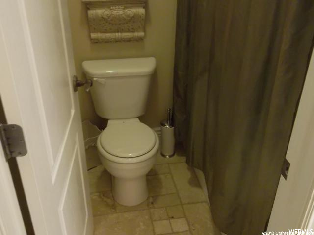 bathroom featuring tile floors, toilet, and shower curtain