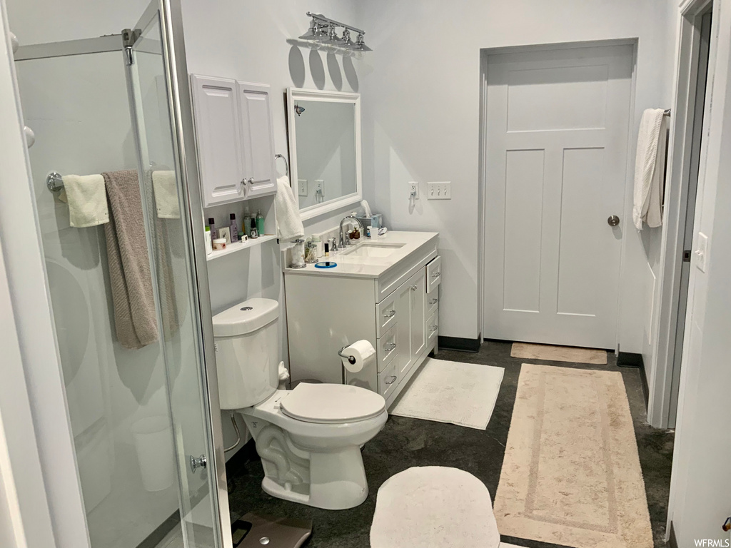full bathroom featuring tile flooring, toilet, vanity, mirror, and shower cabin