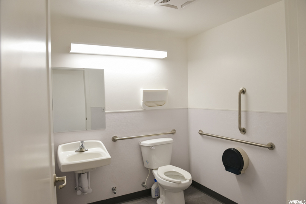 half bathroom featuring toilet, washbasin, and mirror