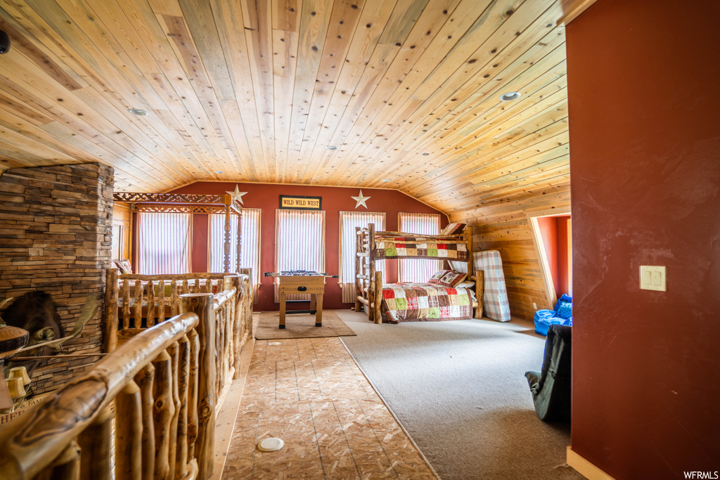 interior space with natural light, carpet, and vaulted ceiling