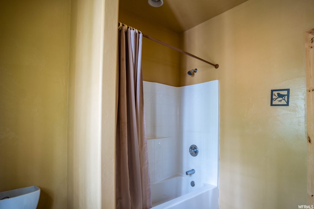 bathroom with shower / washtub combination and shower curtain