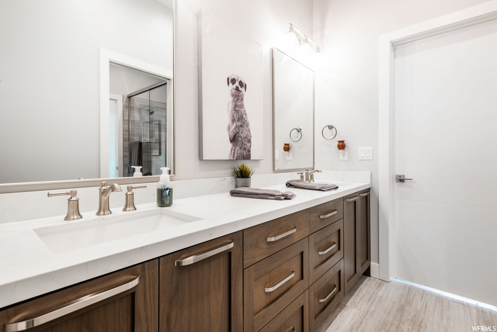 bathroom featuring mirror and dual vanity
