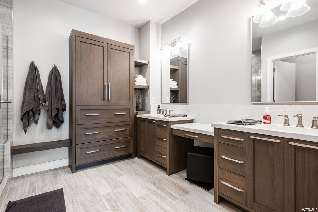 bathroom featuring hardwood floors, mirror, and dual large vanity