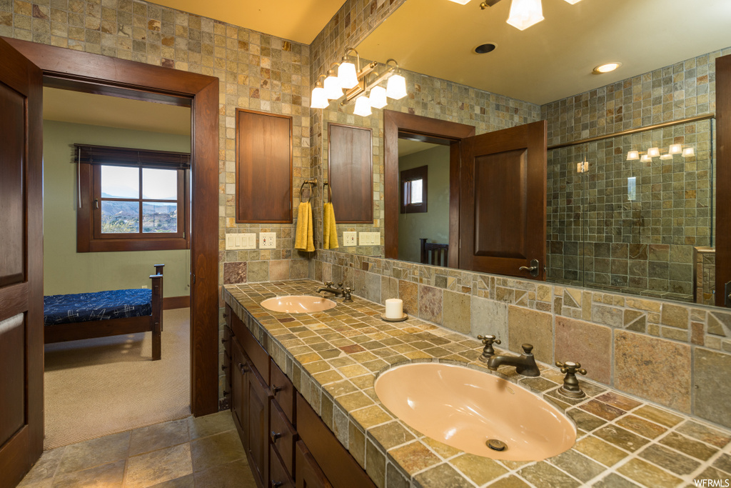 bathroom featuring tile floors, mirror, and double sink vanity